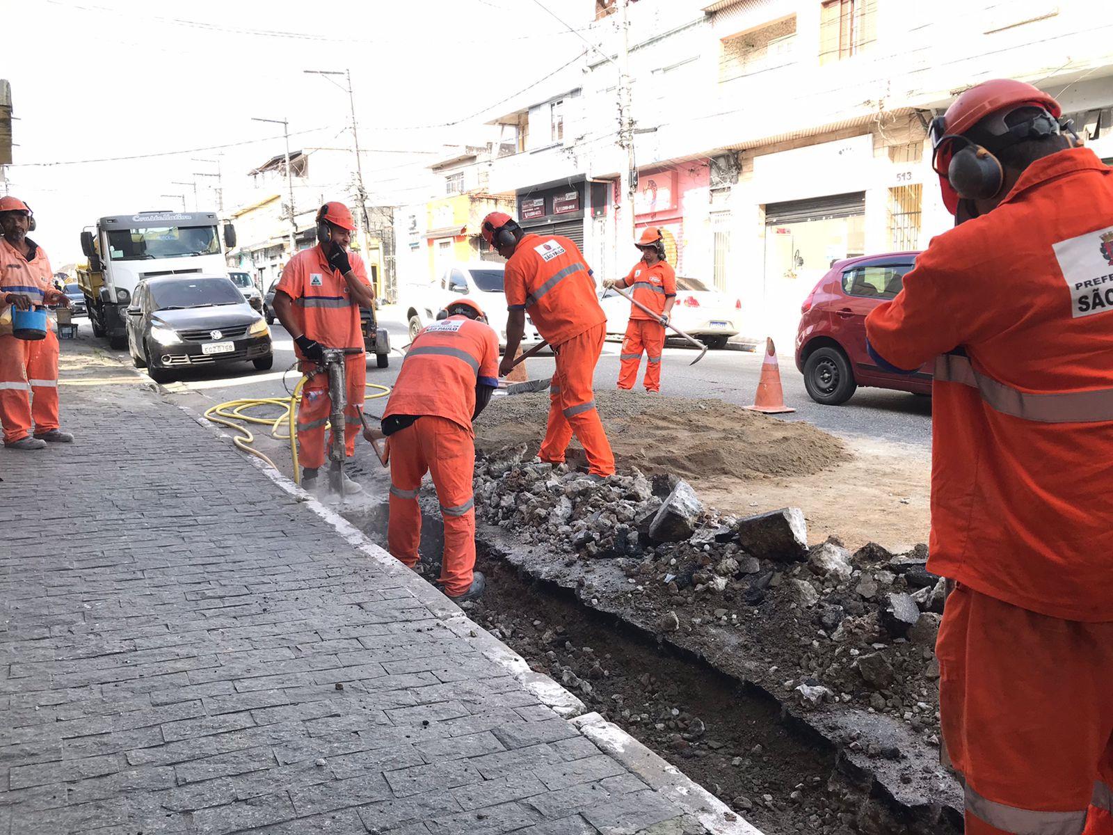 Imagem de equipe de conservação de logradouros realizando alinhamento de guias e sarjetas na avenida Jardim Japão